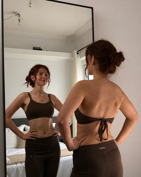 Mujer mirándose con confianza frente a un espejo